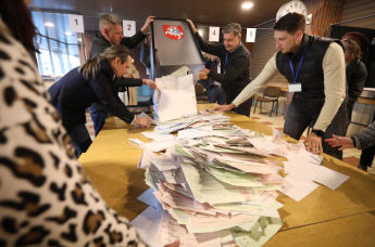 Подсчет бюллетеней на избирательном участке во время первого тура выборов президента Литвы в Вильнюсе, 12 мая 2024 года