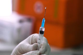 Медицинский сотрудник держит в руках шприц с вакциной от COVID-19