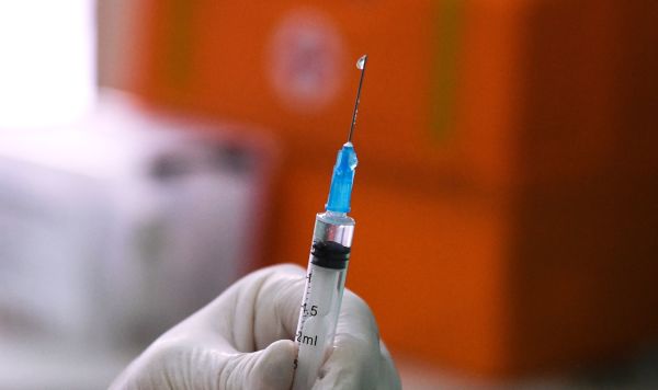 Медицинский сотрудник держит в руках шприц с вакциной от COVID-19