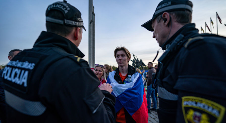 Сотрудники полиции общаются с участниками церемонии возложения цветов у мемориального комплекса "Памятник воинам Советской Армии - освободителям Советской Латвии и Риги от немецко-фашистских захватчиков" в Риге, 10 мая 2022