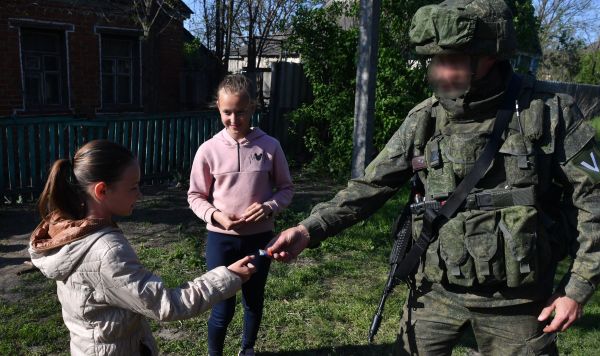 Военнослужащий ВС РФ раздает шоколадки детям одного из сел в Харьковской области
