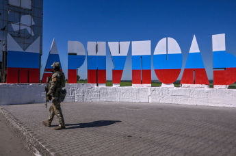 Российский военнослужащий на фоне надписи "Мариуполь"