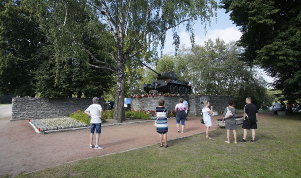 Люди возле памятника танк Т-34 в Нарве, Эстония. Архивное фото
