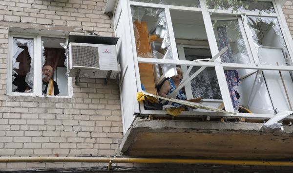 Местные жители в окнах своей квартиры в жилом доме в Киевском районе Донецка, частично разрушенном в результате обстрела со стороны ВСУ, 22 июня 2022