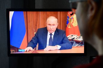Женщина смотрит трансляцию срочного телеобращения президента РФ Владимира Путина к гражданам России, 21 сентября 2022