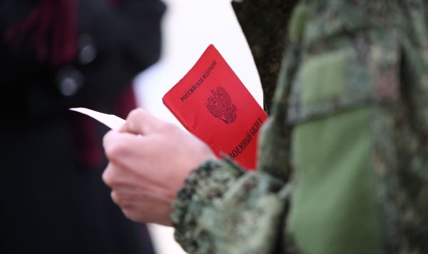 Военный билет в руках мужчины, призванного на воинскую службу в ходе частичной мобилизации в РФ