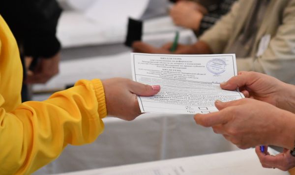 Избиратель получает бюллетень для голосования на референдуме о присоединении Запорожской области к России в Мелитополе