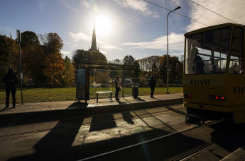 Люди ждут трамвая на остановке в Таллинне, Эстония