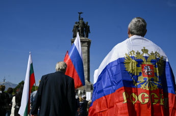 Мужчина с флагом России стоит перед памятником Советской Армии в Софии, Болгария