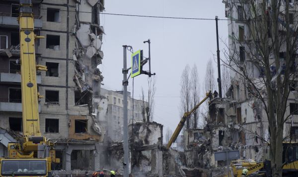 Спасатели работают на разрушенном после ракетного удара жилом доме в Днепре, 16 января 2023 года.