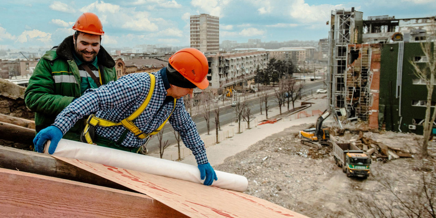 Строители восстанавливают крышу одного из жилых домов в Мариуполе
