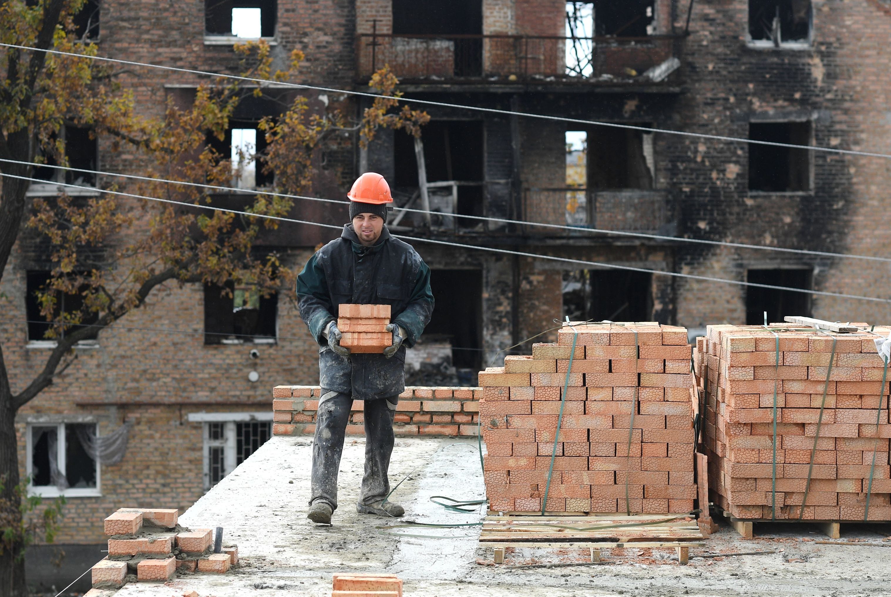 Рабочий восстанавливает жилой дом на улице Центральной в Волновахе