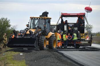 Сотрудники дорожно-строительной компании ремонтируют дорожное полотно в Запорожской области