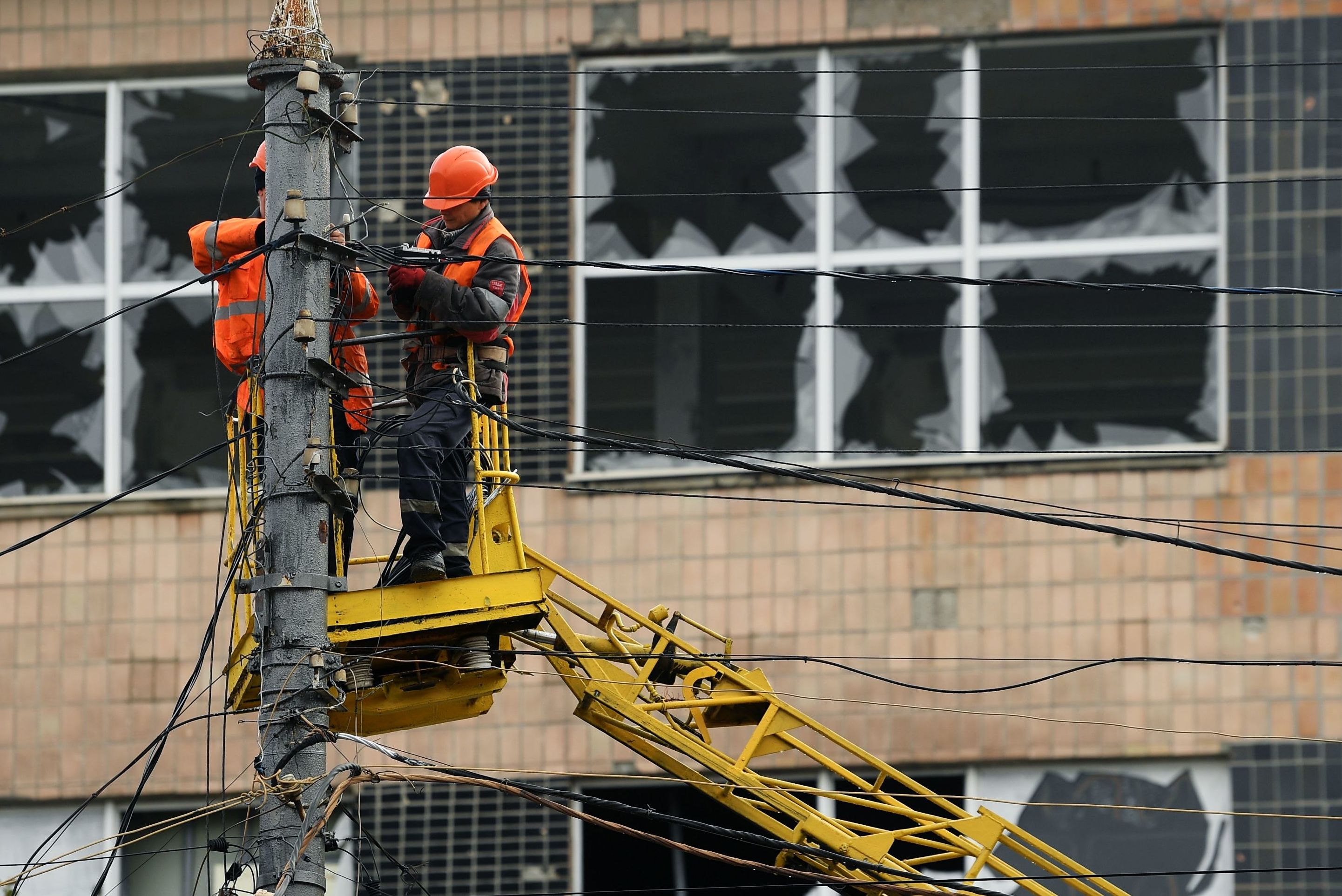 Рабочие во время работ по восстановлению электросетей на одной из улиц в Мариуполе