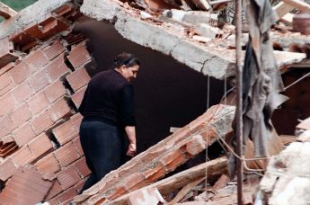 Женщина смотрит на руины своего дома в Сурдулице, 28 апреля 1999 года