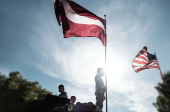 Дети на фоне флагов Латвии и США
