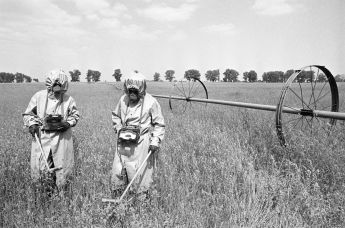 Дозиметристы в специальных костюмах проводят контроль радиации на полях в районе аварии на Чернобыльской АЭС, июнь 1986 года