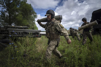 Украинский артиллерист держит 155-мм снаряд