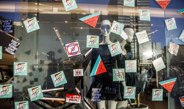 Витрина магазина с наклейками «Свободная Палестина» и «Бойкот Израиля» во время демонстрации в Брюсселе, 17 декабря 2023 года