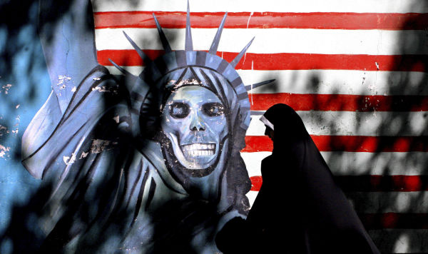 Женщина проходит мимо граффити Статуя Свободы, нарисованная на стене бывшего здания США. Посольство в Тегеране, Иран. Архивное фото