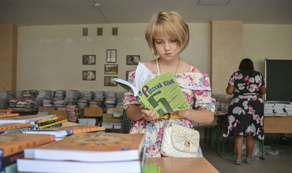 Девочка с учебником русского языка в руках