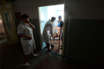 Врачи городской больницы везут в операционную жителя Горловки, раненного во время артиллерийского обстрела города украинской армией.