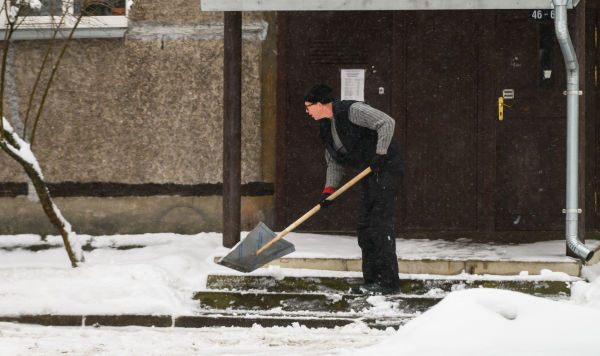 Мужчина убирает снег