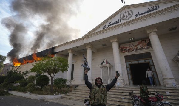 Сирийские повстанцы празднуют победу, в то время как горит здание военного суда в Дамаске