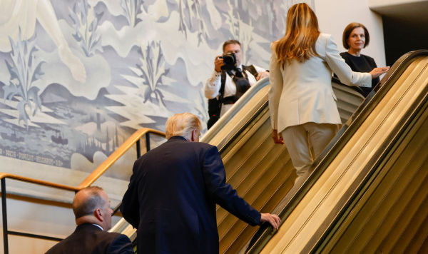 Президент Дональд Трамп (в центре) и первая леди Мелания Трамп (справа вверху) поднимаются по эскалатору в штаб-квартире ООН во вторник, 23 сентября 2025 г.