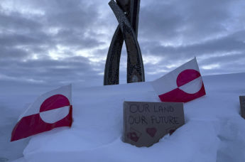 Флаги Гренландии и табличка с надписью "Наша земля – наше будущее"