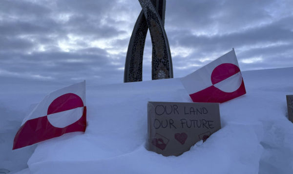 Флаги Гренландии и табличка с надписью "Наша земля – наше будущее"