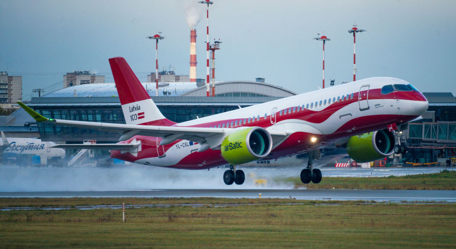 Самолет авиакомпании  airBaltic Airbus A220-300 в цветах латвийского флага в аэропорту Рига