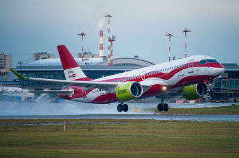 Самолет авиакомпании  airBaltic Airbus A220-300 в цветах латвийского флага в аэропорту Рига