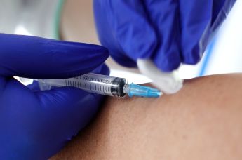 Медик делает прививку с вакциной против гриппа