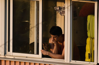 Молодой человек на балконе многоквартирного дома
