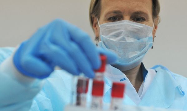 Лаборант подготавливает биоматериал (кровь) для центрифугирования