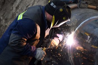 Сварщик ремонтирует участок магистрального нефтепровода "Дружба" в районе деревни Романовка в Гомельской области