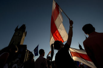 Люди с флагами принимают участие в демонстрации в поддержку протестов против результатов президентских выборов в Беларуси, Прага, Чехия 16 августа 2020 года
