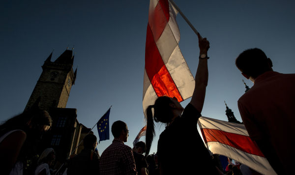 Люди с флагами принимают участие в демонстрации в поддержку протестов против результатов президентских выборов в Беларуси, Прага, Чехия 16 августа 2020 года