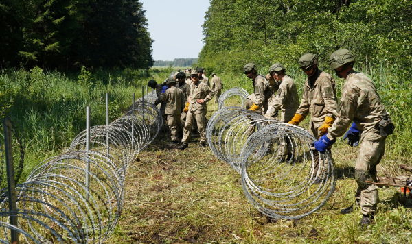 Солдаты литовской армии устанавливают колючую проволоку на границе с Беларусью, Литва, 9 июля 2021 года