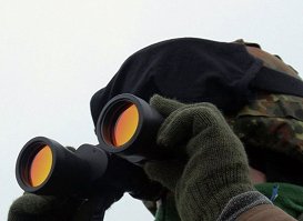 Военный смотрит в бинокль.