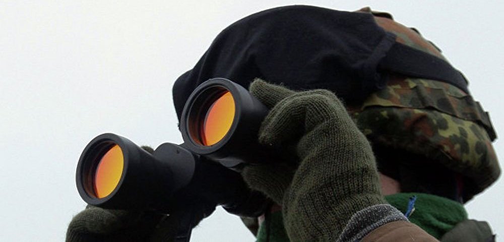 Военный смотрит в бинокль.