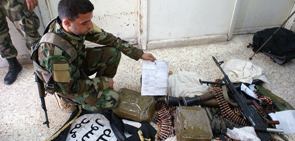 Сирийские военнослужащие досматривают оружие и вещи боевиков ИГИЛ, захваченных в результате боев в Сирии.