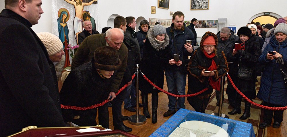 Прихожане фотографируют документ (томос) содержащий решение Священного Синода Вселенского патриархата о предоставлении автокефалии Украинской православной церкви