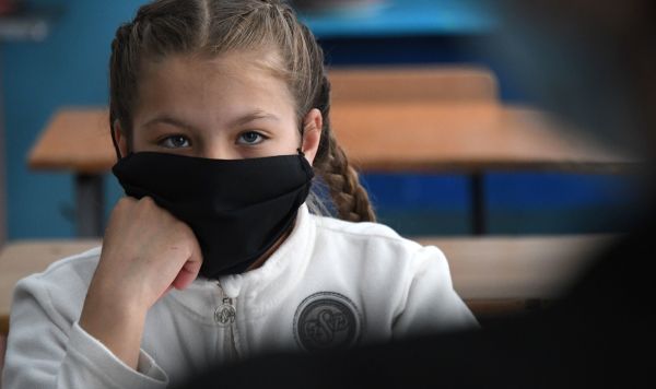 Ученица в защитной маске на уроке в школе
